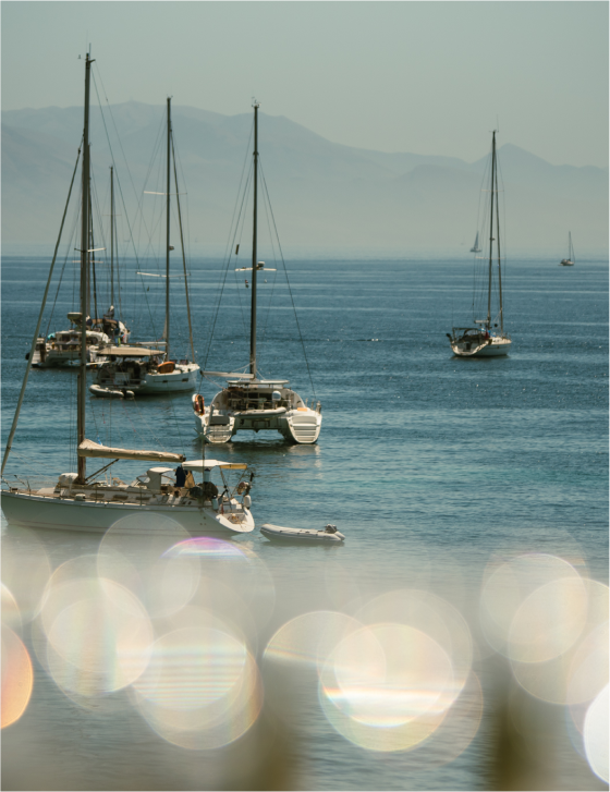 Scenic view of the sea in front of Azur, with yachts and mainland Greece in the backdrop, creating a picturesque setting.